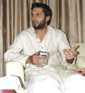 A cricketer and a gentleman: Shahid Afridi holds the tape recorder for Newsline's Farieha Aziz, ensuring that she has a clear record of every word from the interview performed at his Karachi home in April 2011. Photo: Saif Karamali