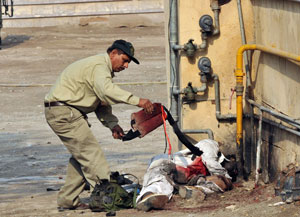 The ultimate sacrifice: Stripping a bloodied suicide vest from an attacker's dead body. Photo: AFP