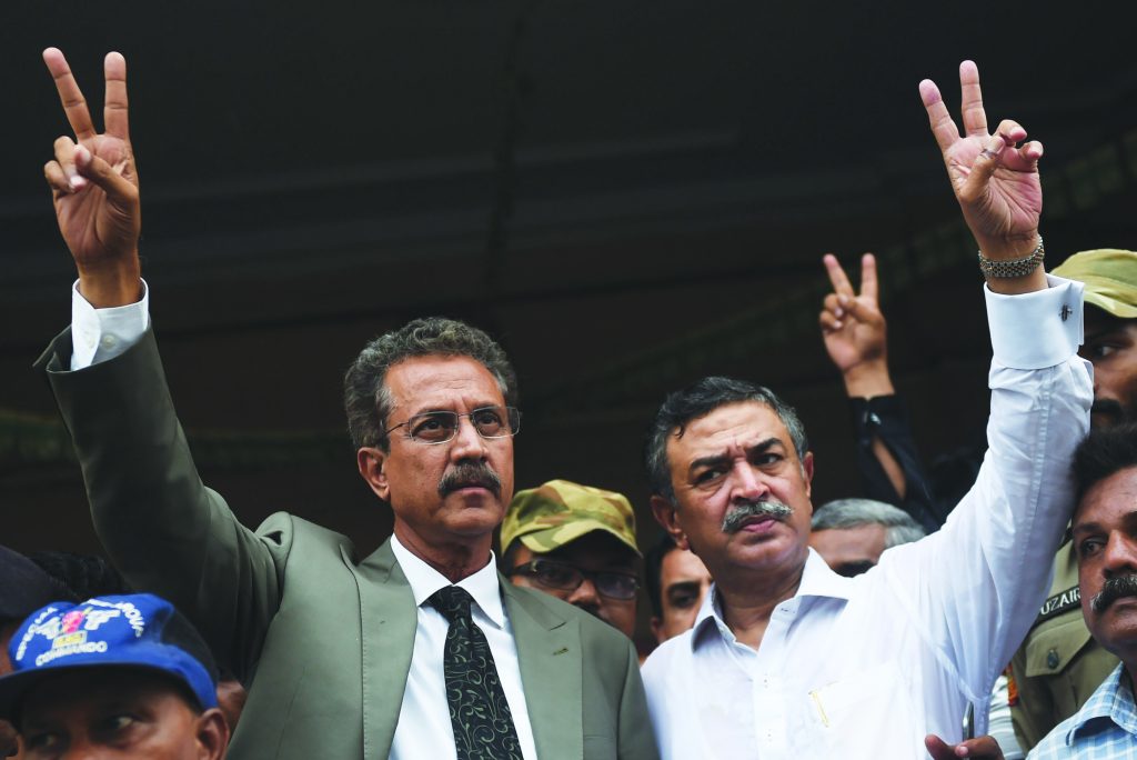 Newly elected mayor of Karachi of the influential Muttahida Qaumi Movement (MQM) party, Waseem Akhtar (L) and his deputy mayor Arshad Vohra flash victory signs after winning the mayoral election in Karachi on August 24, 2016. The Pakistani port megacity of Karachi on August 24 elected as mayor a politician who is currently in jail on sedition and terrorism charges, a day after the leader of his party was charged with treason. Waseem Akhtar, a former minister and parliamentarian of the influential Muttahida Qaumi Movement (MQM), won by a landslide with 196 of the total 294 votes cast by the city's municipal authorities. Akhtar was arrested in July 2016 and accused of ordering a crackdown on city riots in 2007, when he was serving as provincial home minister, that resulted in a bloody massacre. / AFP PHOTO / RIZWAN TABASSUM