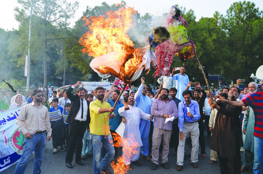 Pakistani Kashmiris burn effigies of Indian Prime Minister Narendra Modi and Foreign Minister Sushma Swaraj during a protest in Islamabad, on September 26, 2016, to show their solidarity with Indian Kashmiri Muslims. Indian Prime Minister Narendra Modi lashed out at Pakistan last week accusing it of "exporting terrorists" after a deadly attack on an army base that New Delhi has blamed on Pakistan-based militants. Modi's comments were the latest in a war of words between the neighbours over escalating tensions in disputed Kashmir, where 18 Indian soldiers were killed last week in the worst attack in the region for over a decade. / AFP PHOTO / AAMIR QURESHI