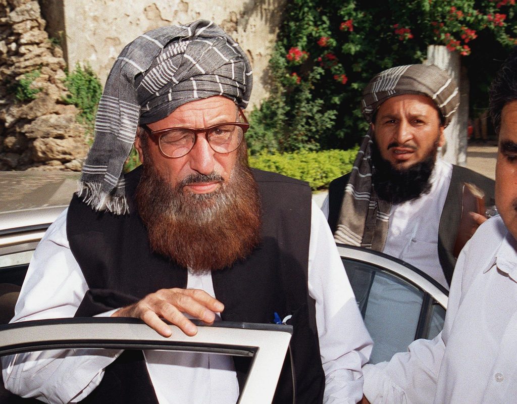 Maulana Samiul Haq (L), chairman of the council for the defence of Afghanistan, coming out of his car for a press conference in Rawalpindi, some 25km from Islamabad, 19 September 2001. Haq told the press conference that the council, which consists of several main religious parties, decided to mark protests across the country against the Pakistani government for its support of the US. Unidentified aid of Haq is at right. (FILM) AFP PHOTO