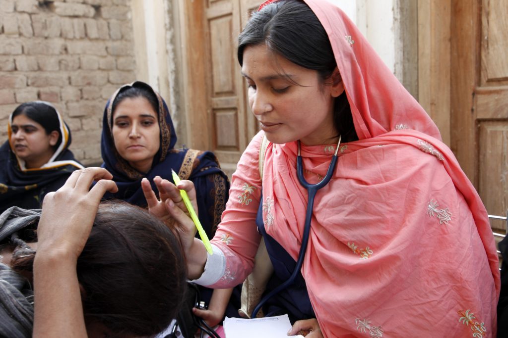 A female doctor with the International Medical Corps examines a woman patient at a mobile health clinic in the village of Goza, near Dadu in Pakistan's Sindh province. Funding from the UK government is enabling the International Medical Corps to operate mobile health clinics in Sindh, as part of the UK's response to the Pakistan floods. These clinics will provide access to basic healthcare services for thousands of people across Sindh as they return home to communities which were devastated by the floods in August 2010. The floods destroyed clinics and hospitals as well as homes and schools, so mobile teams of doctors, nurses and pharmacists are a vital way of reaching people in need of healthcare. The teams also operate as a disease 'early-warning' system; being getting out into the communities, they can spot the early signs of cholera and other water-borne diseases associated with large amounts of standing water and limited sanitation.