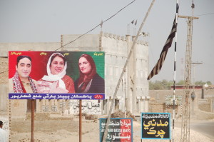 Sindh’s changing landscape: A SSP flag next to a Bhutto family hoarding.
