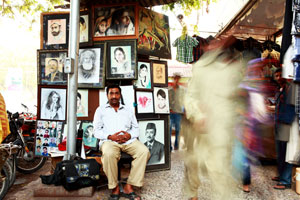 Urban gallery: Mohammed Zafarullah sits in front of his wall of work. Photo: Danish Khan