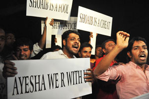 The dumped: Supporters hold placards and cheer for Ayesha Siddiqa, Shoaib's first wife, who he was forced to divorce. Photo: AFP
