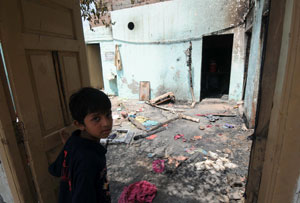 Nothing new: A boy looks on at the consequences of burning and looting of Christian homes by Muslims. Many such incidents have occurred in Pakistan in 2009. Photo: AFP.