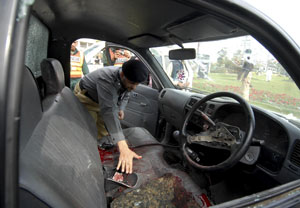 A Pakistani policeman inspects a police vehicle after masked gunmen attacked the Sri Lankan cricket team in Lahore on March 3, 2009. Masked gunmen opened fire on the Sri Lankan cricket team's bus in the eastern Pakistani city of Lahore, killing at least eight people and wounding six team members, police said. AFP PHOTO/Arif ALI