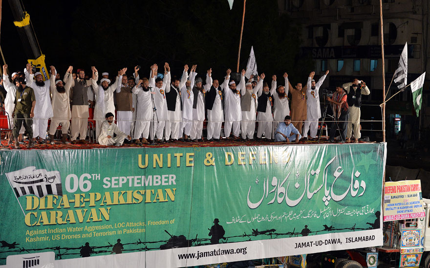 Leaders of Pakistani Islamist groups and the Defence of Pakistan Coalition join hands on a stage, set up on a container truck, during an anti-India rally in Islamabad on September 6, 2013 to mark the country’s Defence Day. Thousands supporters of Pakistani Islamist groups and Defence of Pakistan coalition marched against India in Islamabad as they celebrated Defence Day, a commemorative day of the war fought against neighboring India in 1965. AFP PHOTO / AAMIR QURESHI