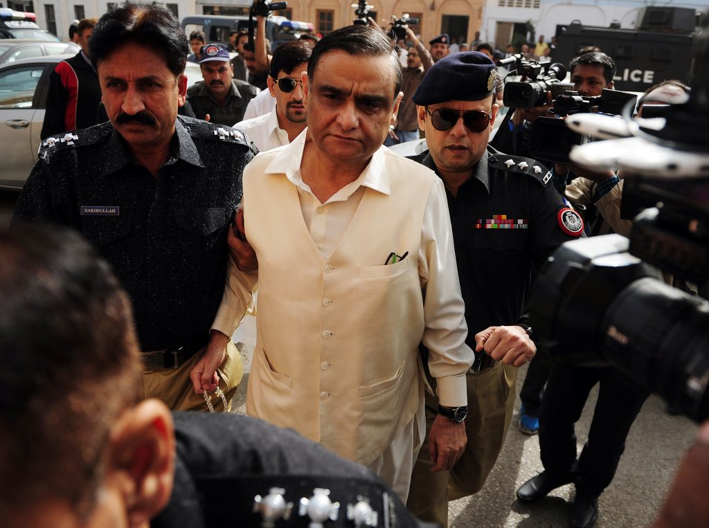 Pakistani police officials escort ex-petroleum minister Asim Hussain (C), a close aide to former president Asif Zardari, as they arrive at a court in Karachi on December 11, 2015. An accountability court on December 11 remanded former former federal minister Asim Hussain into the custody of the National Accountability Bureau (NAB) for seven days. AFP PHOTO / ASIF HASSAN / AFP / ASIF HASSAN