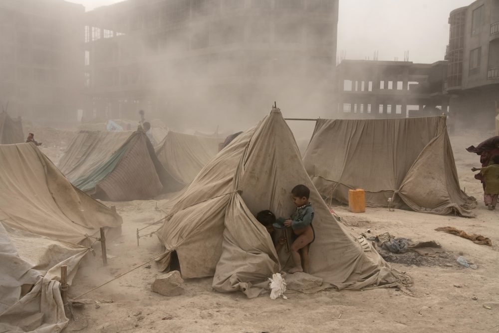 An Afghan refugee child hides from a dust storm behind a tent at a refugee camp in Kabul on October 7, 2008. Over a quarter million Afghans have returned home this year from Pakistan and Iran, many of them reportedly due to economic and security uncertainties faced in exile, the United Nations said. AFP PHOTO/ Manpreet ROMANA