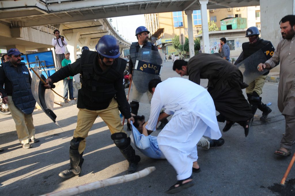 Pakistani policemen arrest an activist of Pakistan Tehreek Insaaf 